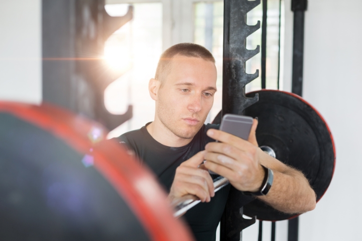 トレーニング中にスマホをいじる男
